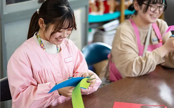 画用紙を切っている市立保育園の先生の画像