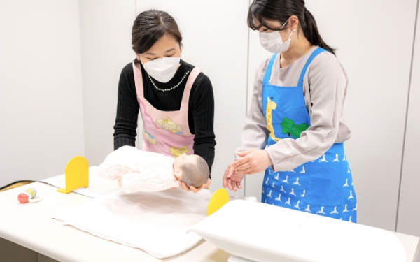 赤ちゃんの身長を測る健康支援課の人の画像